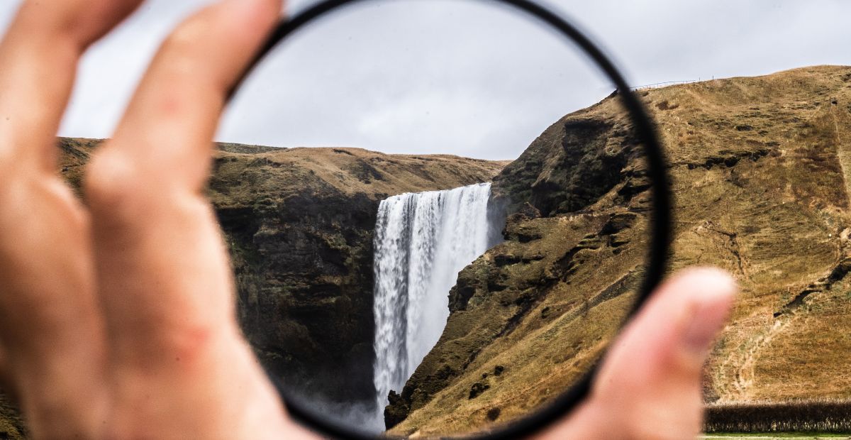 Magnifying glass in front of a waterfall
